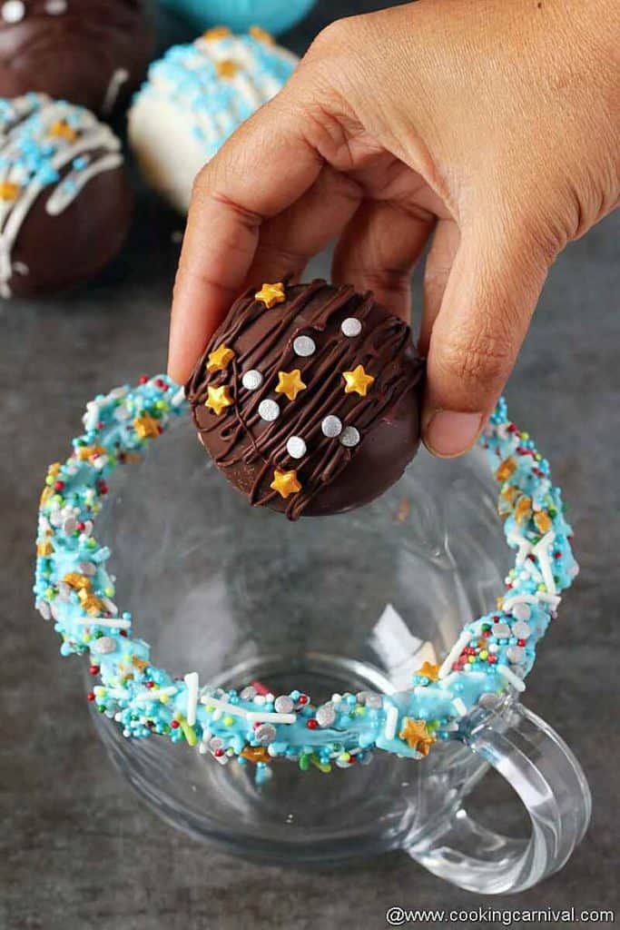 adding hot chocolate bomb in a coffee mug