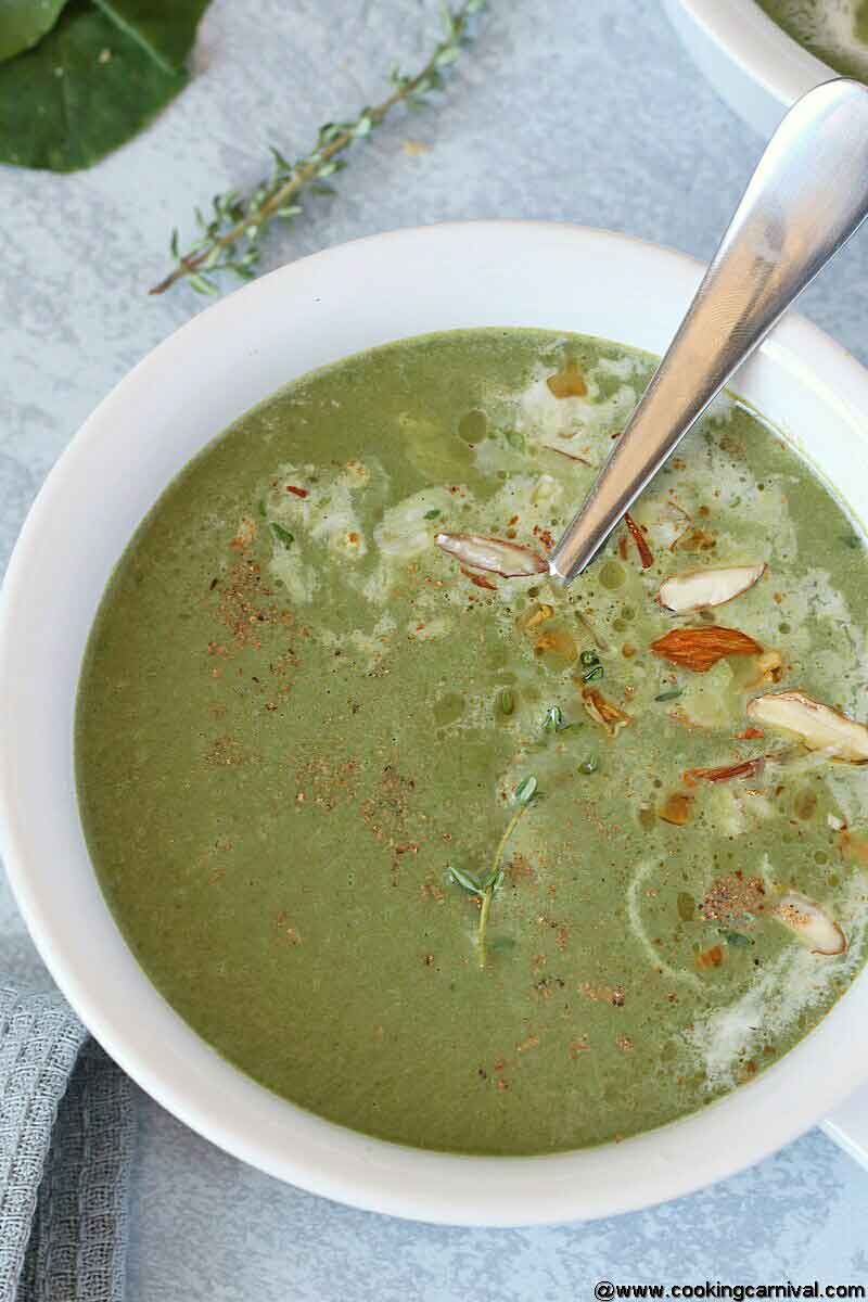 Spinach soup in white bowl with spoon