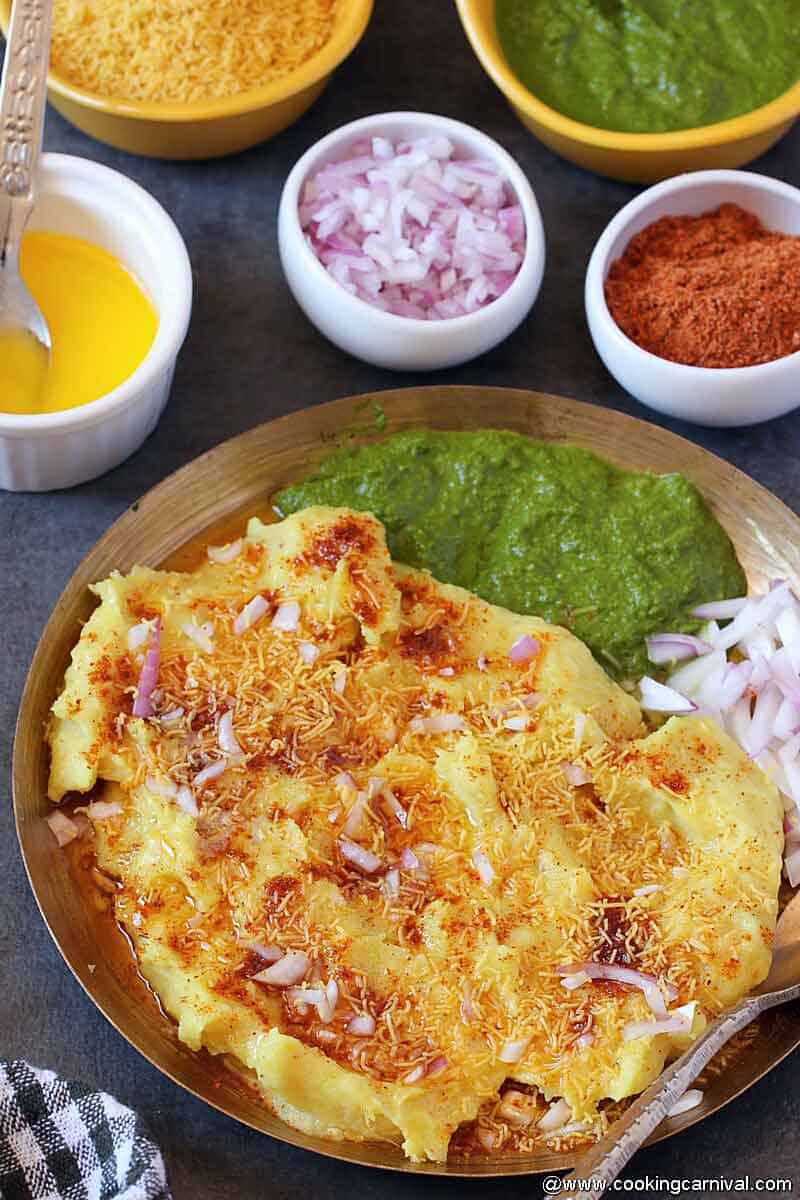 Locho topped with masala, butter, sev and green chutney