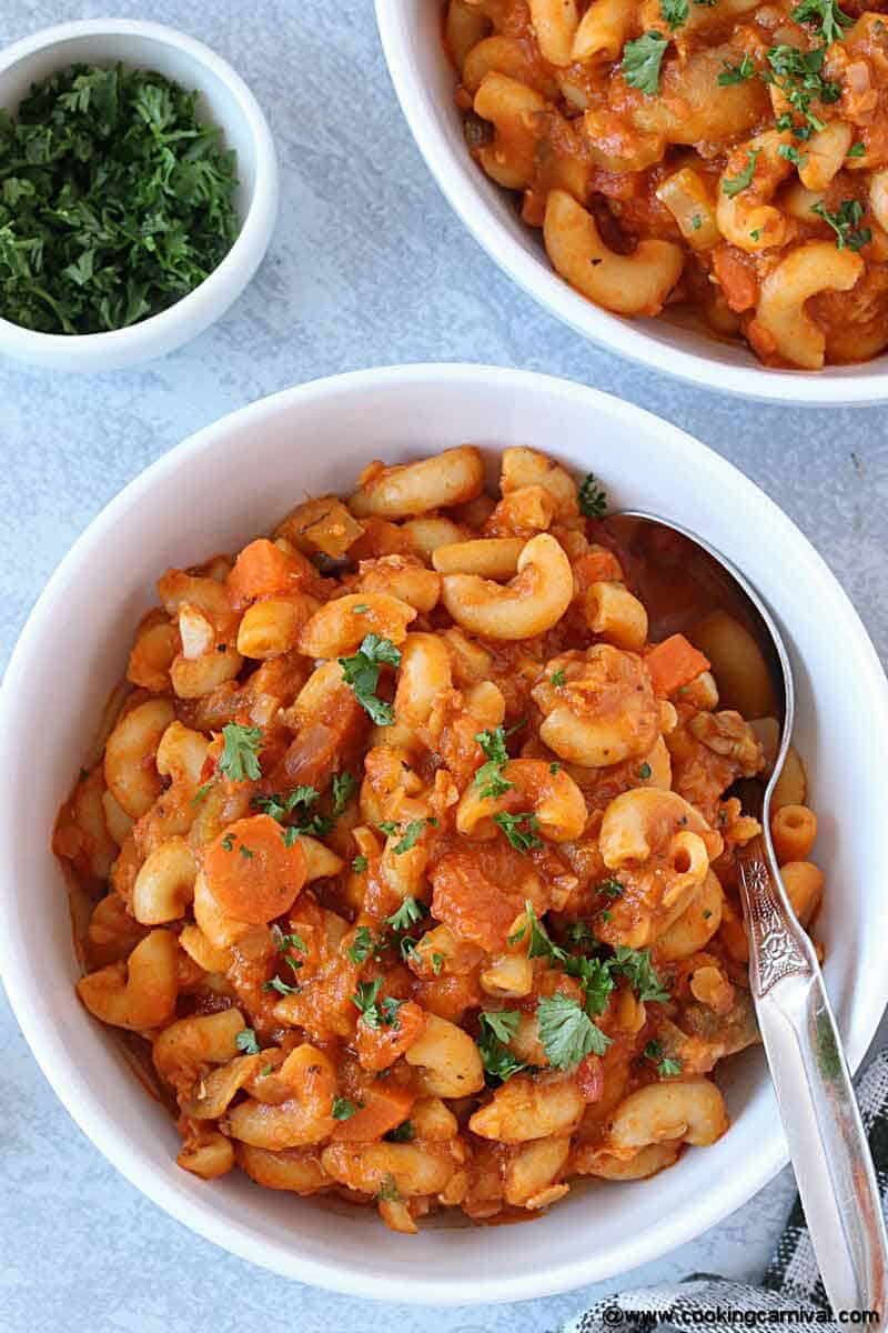 Vegan Instant pot Goulash in a white bowl with spoon, close up shot
