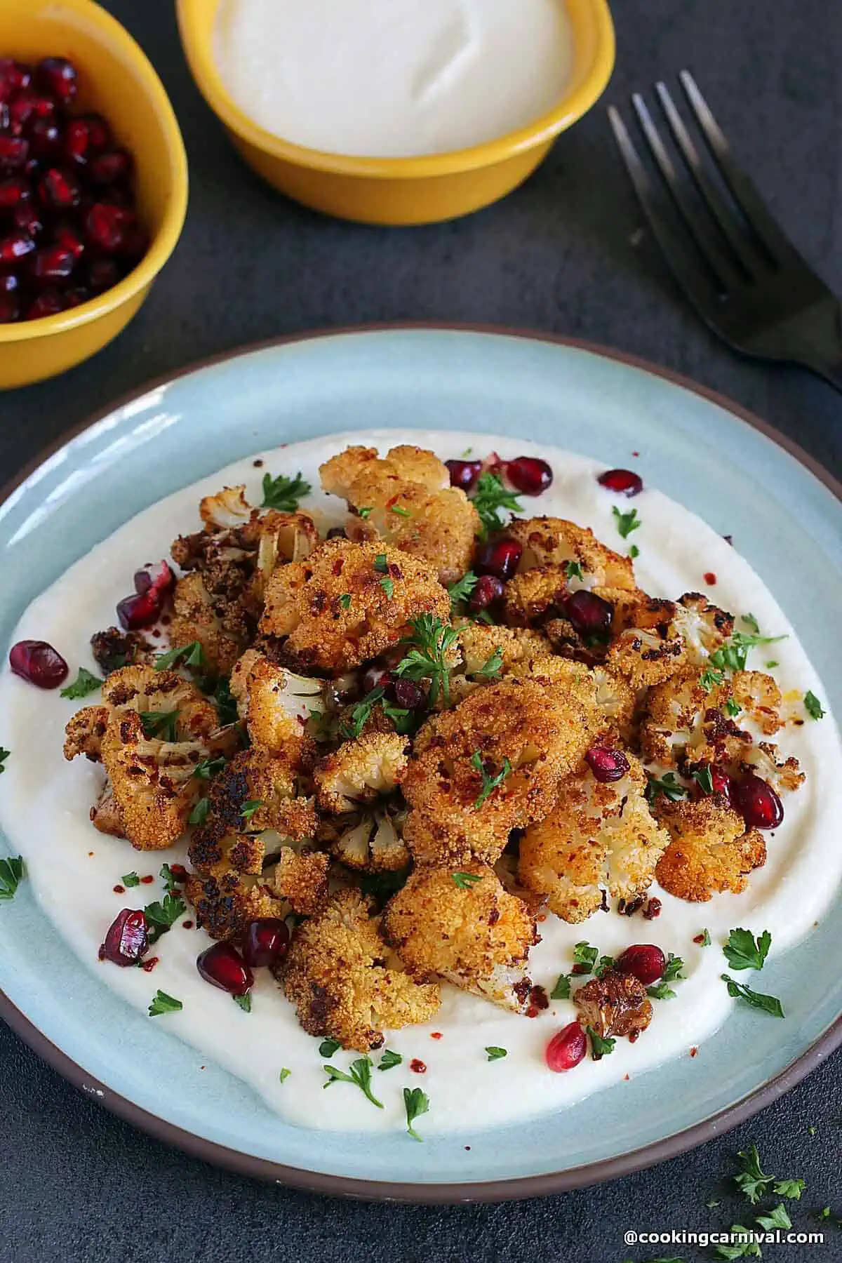 Roasted cauliflower with lemony whipped feta, garnished with pomegranate and parsley.